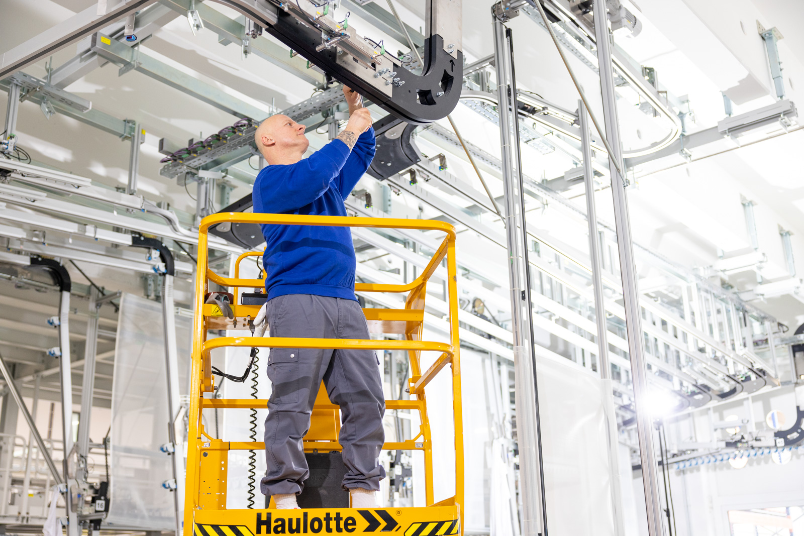 Ein Elektriker bei der Arbeit an einer modernen Produktionsanlage der Wäscherei Diener
